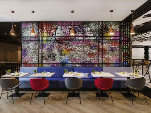 a dining room with a blue table and red chairs at Mercure Budapest Castle Hill in Budapest