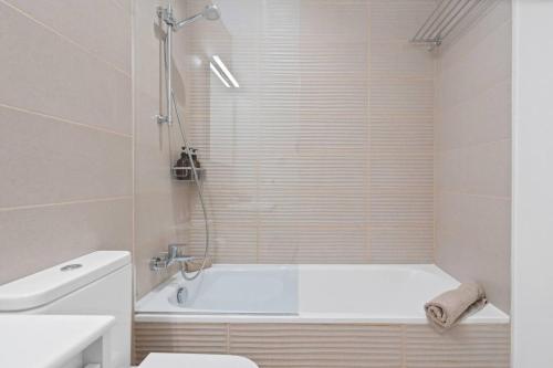 Un baño con bañera, inodoro y lavabo. en Sea View Apartment Estepona - Célere Sea Views, en Estepona