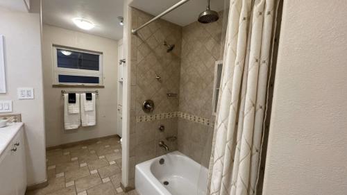 a bathroom with a tub and a shower with a shower curtain at Frontier Lux 2 Bedroom in Hamilton Acres