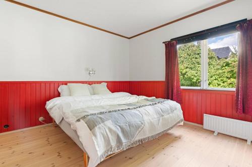 a bedroom with red and white walls and a large bed at Roestbakken Horizon in Guleng