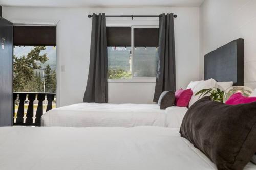 two white beds in a bedroom with a window at Gateway Suites Charming Stay perfect for 4 Guests in Canmore