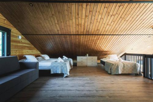 Un dormitorio con dos camas y techo de madera. en Stay North - Jyrkäs, en Pojo