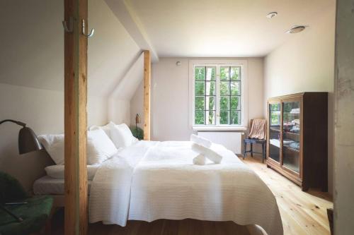 Un dormitorio con una cama blanca grande y una ventana en Stay North - Honkala, en Ruissalo