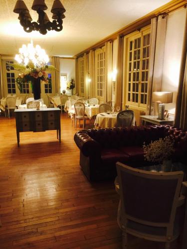 a living room with a couch and tables and chairs at Le Cheval Blanc in Jargeau