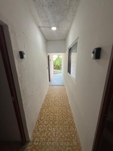 a hallway leading to a room with white walls and a hallwayngth at La Vecindad in Querétaro