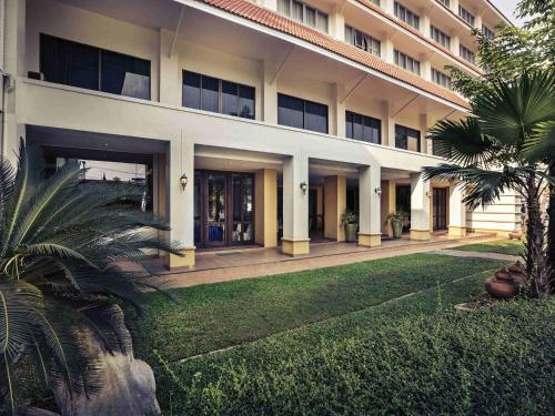 a large building with a lawn in front of it at Mercure Chiang Mai in Chiang Mai