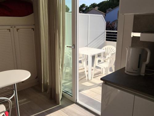 a kitchen with a balcony with a table and chairs at Dune Prestige & Chalets in Bibione