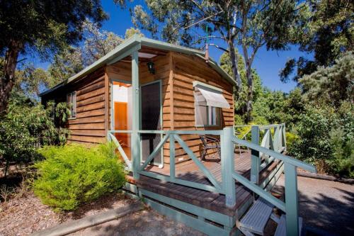 a cabin in the woods with a porch at Shepparton Holiday Park in Shepparton