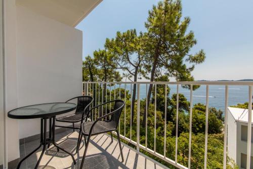 einen Balkon mit einem Tisch und Stühlen sowie Meerblick in der Unterkunft Aminess Casa Bellevue in Orebić