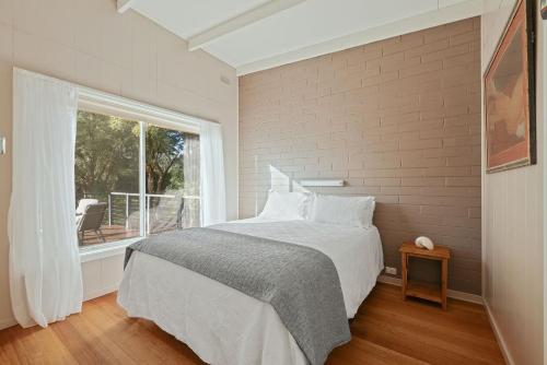 una camera da letto con un letto grande e una finestra di Honeysuckle Beach Haven a Cowes