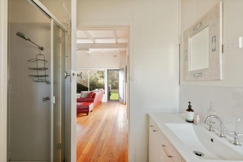 bagno con lavandino e divano rosso di Honeysuckle Beach Haven a Cowes