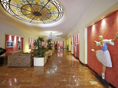 a lobby with a statue of a woman on the wall at Mercure Reggio Emilia Centro Astoria in Reggio Emilia
