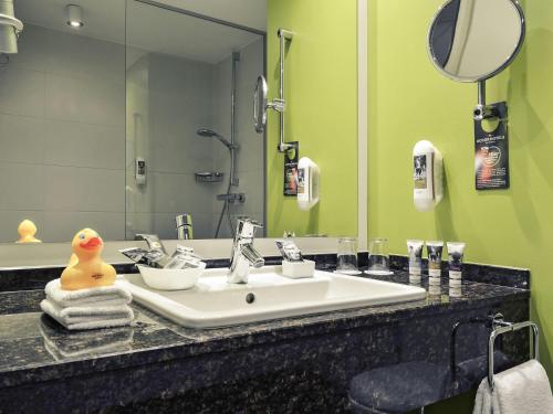 a bathroom with a sink with a rubber duck on it at Mercure Hotel Koblenz in Koblenz