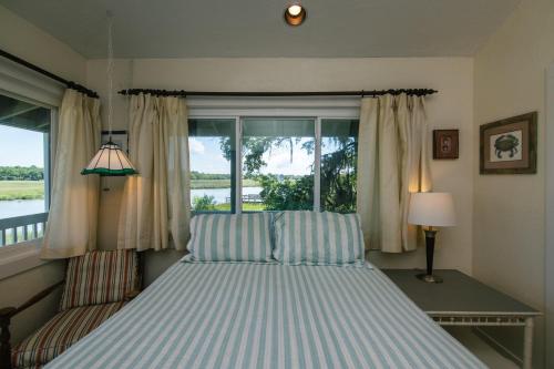 a bed in a bedroom with a window at Shrimpers Cove in Edisto Island