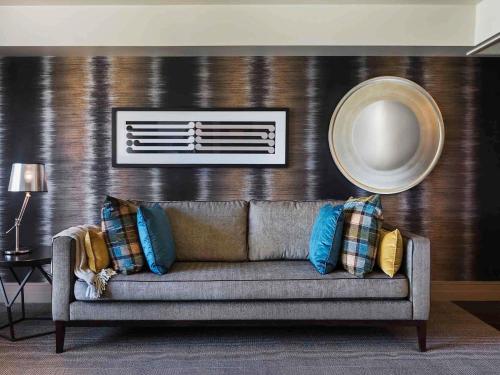 a couch with pillows on it in a living room at Hotel St Moritz, Queenstown - MGallery Collection in Queenstown