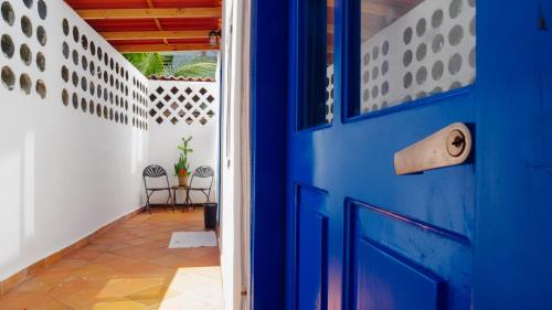 a blue door in a hallway with a table and chairs at CASA DINIS -CASA GRANDE -CENTRO DE PORTOBELo in Portobelo