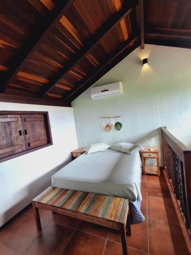 a bedroom with a bed and a wooden ceiling at Vila Artesania in Bombinhas