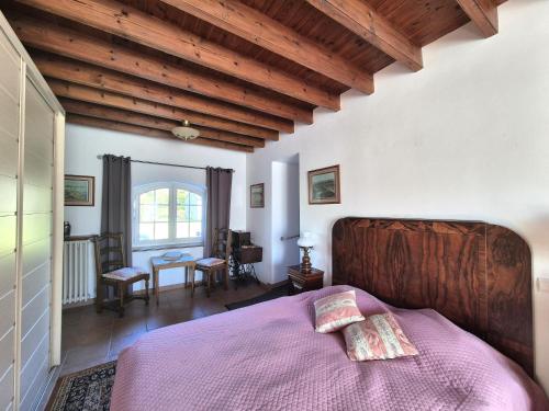 een slaapkamer met een bed en een houten plafond bij Spacious Family Home Near the Sea in Denneville