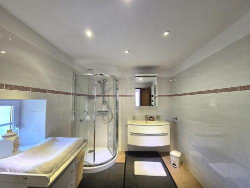 een badkamer met een douche en een wastafel bij Spacious Family Home Near the Sea in Denneville