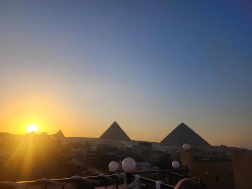 a view of the pyramids of giza at sunset at Eyad Pyramids view in Cairo