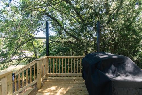 a wooden deck with a fence and a tree at Edisto Echo in Edisto Beach