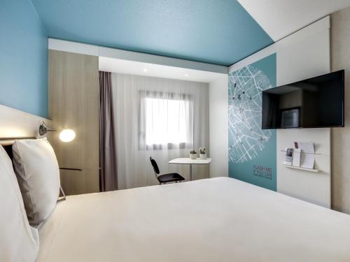 a hotel room with a large white bed and a chair at Mercure Paris Gare De Lyon TGV in Paris