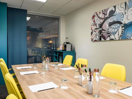 a conference room with a long table and yellow chairs at Mercure Paris Gare De Lyon TGV in Paris