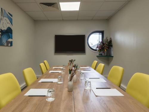 a conference room with a long table and yellow chairs at Mercure Paris Gare De Lyon TGV in Paris