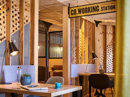 a room with a table and a sign that reads ca working station at Mercure Paris Gare De Lyon TGV in Paris