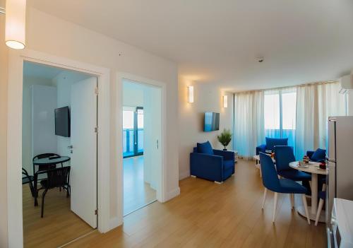 uma sala de estar com cadeiras azuis e uma mesa em Panorama SeaSide Central Hotel em Batumi