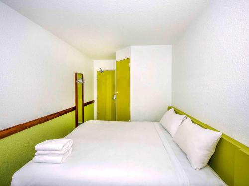 a small room with a bed with green and white at ibis Budget - St Peters in Sydney