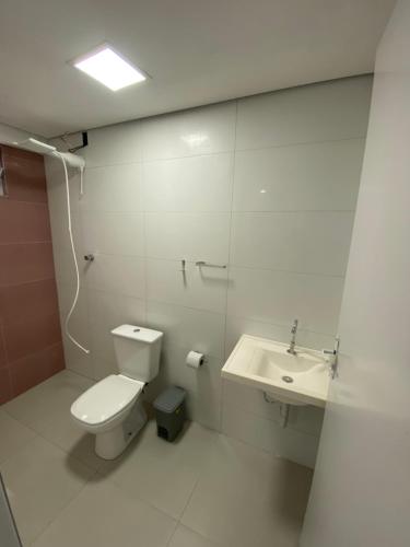 Un baño blanco con inodoro y lavabo. en Studios Mattigor - ao lado da Dutra em Caçapava-SP, en Caçapava