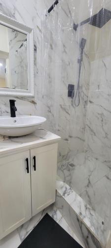 a white bathroom with a sink and a shower at Very Ralaxing in Saint Georgeʼs