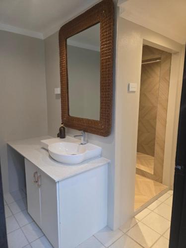 a bathroom with a sink and a mirror on a counter at MIRZ Accomodation Villa 2 in Pacific Harbour