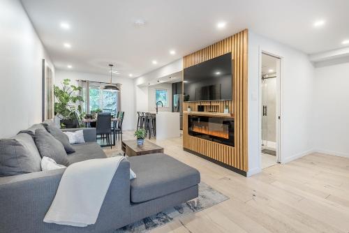 a living room with a gray couch and a fireplace at FREE PARKING PRIME LOCATION NEW MODERN CONDO in Brossard