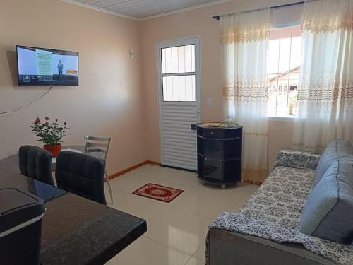 a living room with a blue couch and a tv at Apart hotel - 2 tranquilidade e conforto de casa in Tuparendi