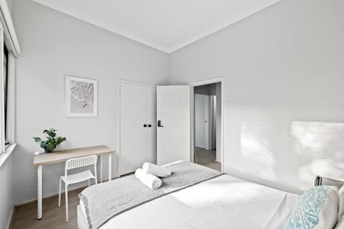 a white bedroom with a bed and a desk at Modern Private Double Room - Centrally Located - Shared Bathroom