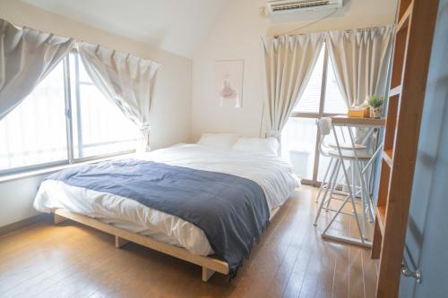 un lit dans une pièce avec deux fenêtres et une échelle dans l'établissement リトリートコートpaypayドーム, à Fukuoka