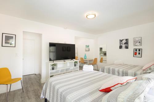 a bedroom with two beds and a flat screen tv at The Oasis in Miami