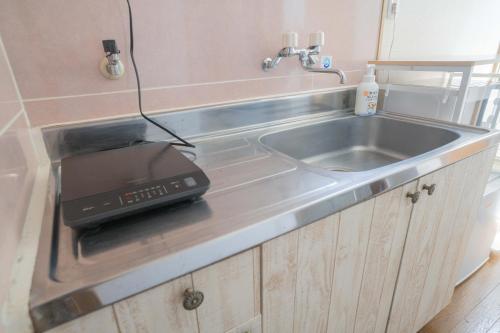 Il comprend une cuisine équipée d'un évier et d'un grille-pain. dans l'établissement リトリートコートpaypayドーム, à Fukuoka