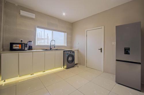 a kitchen with a washing machine and a sink at The Metropolis Lekki in Lekki