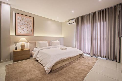 a bedroom with a large bed and a large window at The Metropolis Lekki in Lekki