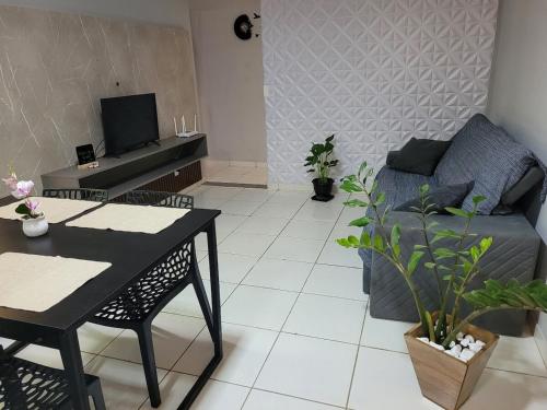 una sala de estar con un sofá y una mesa en Apartamento confortável com ar condicionado, en Montes Claros