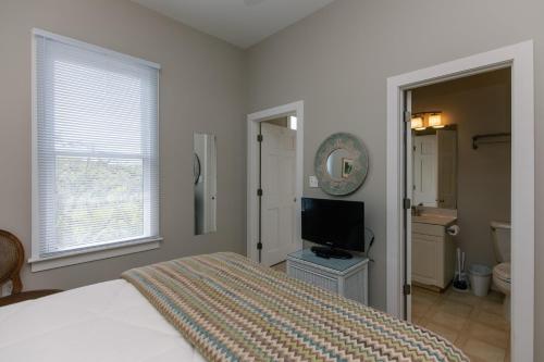 a bedroom with a bed and a flat screen tv at Tequila Sunset in Edisto Island
