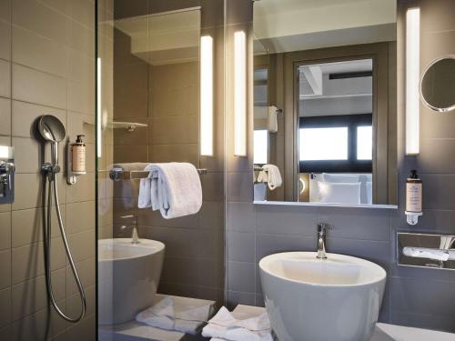 a bathroom with a sink and a toilet and a mirror at Mercure Roma Centro Colosseo in Rome