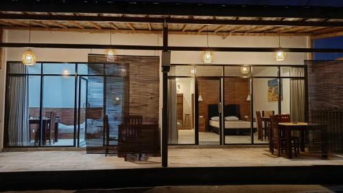 a room with glass doors with a table and a bedroom at Mentari in Gili Gede
