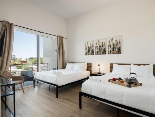 a hotel room with two beds and a balcony at HiRise - Modern Luxe - Jacuzzi - Heart of Old Town in Scottsdale