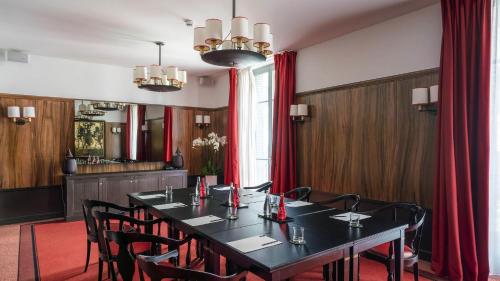 a conference room with a black table and chairs at Carlton Hotel Lyon - MGallery Collection in Lyon