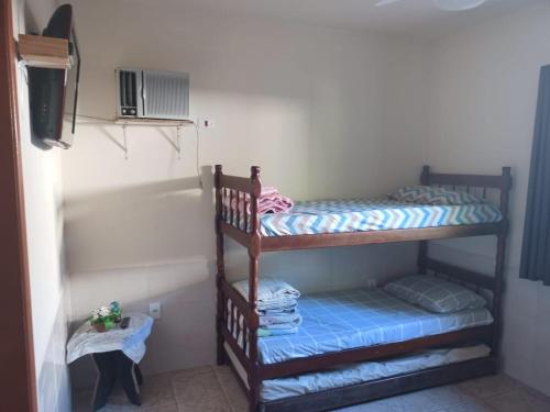 two bunk beds in a room with a tv at Pousada costa in Paraty