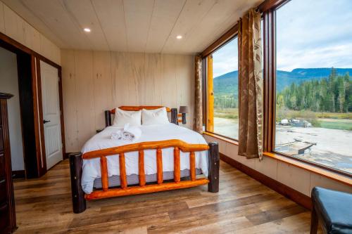 ブルーリバーにあるRiver Safari Lodgeのベッドと大きな窓のある寝室